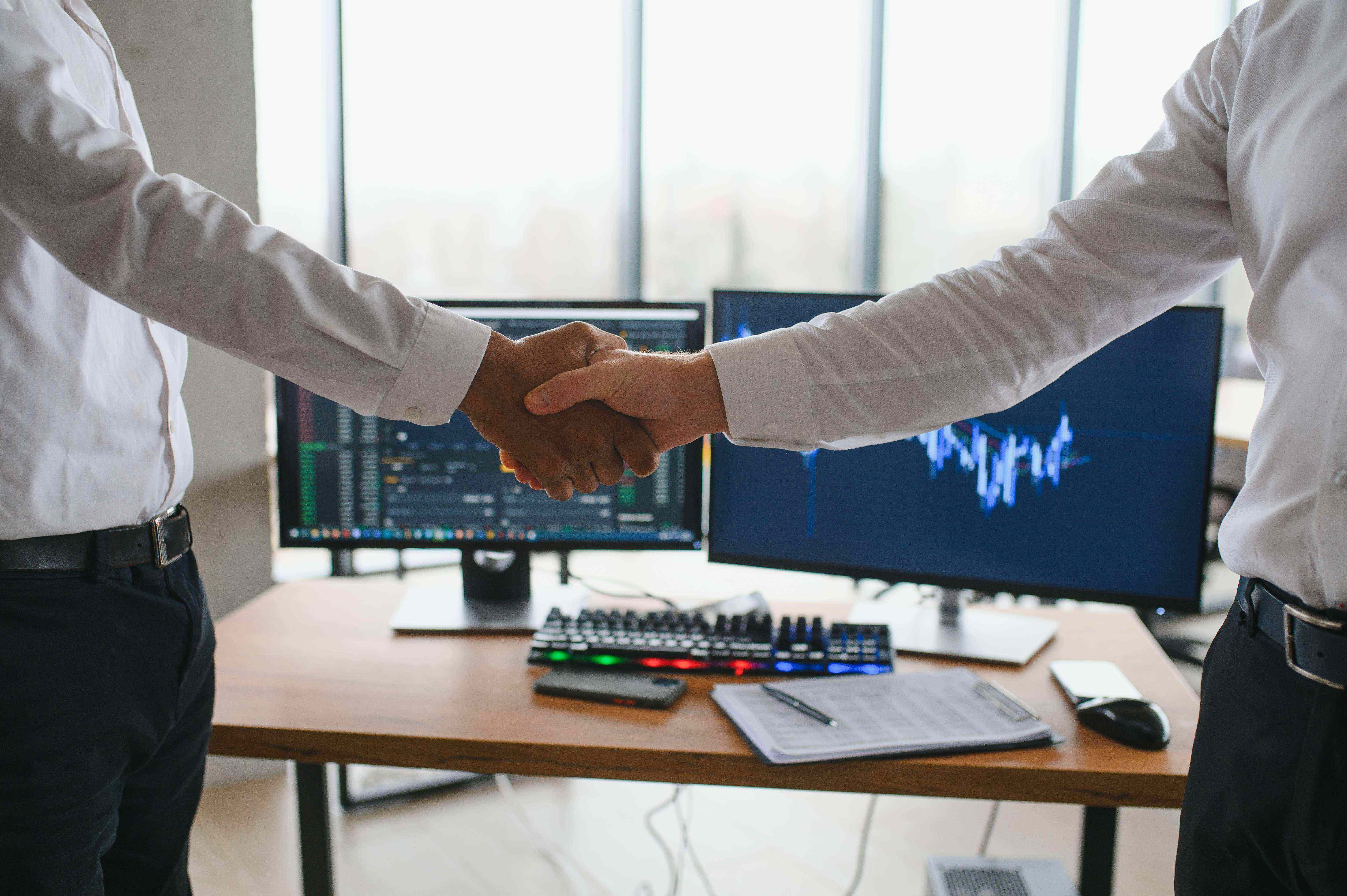 Apretón de manos entre empresario y consultor tecnológico, sellando una alianza estratégica de transformación digital